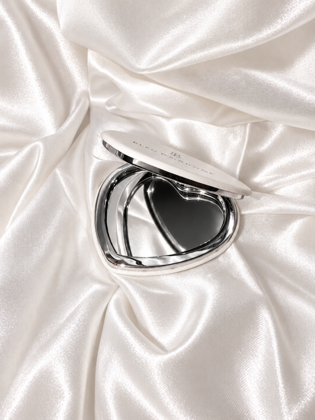Open heart compact mirror on white satin